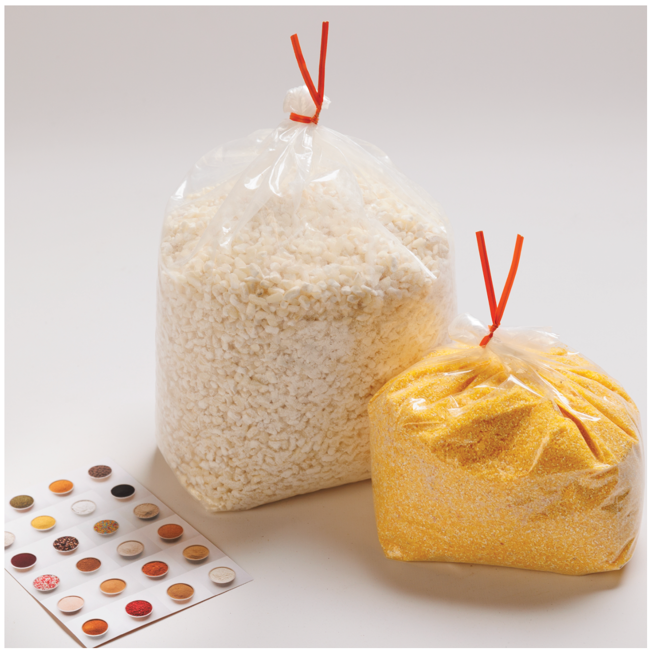 Two clear bags of white and yellow corn with a RHBULK card next to bags