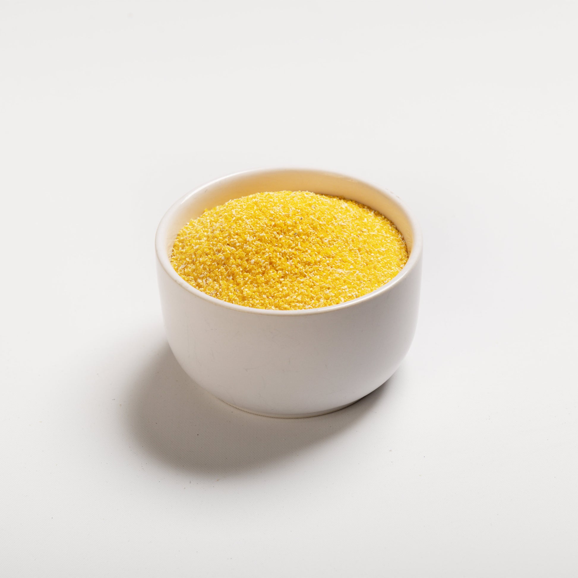 White bowl filled with yellow grits (#18) on a white background