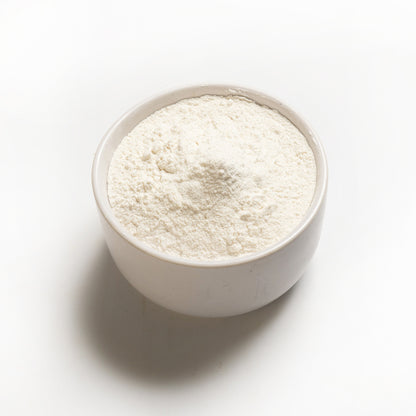 A bowl of white cassava flour on a white background.