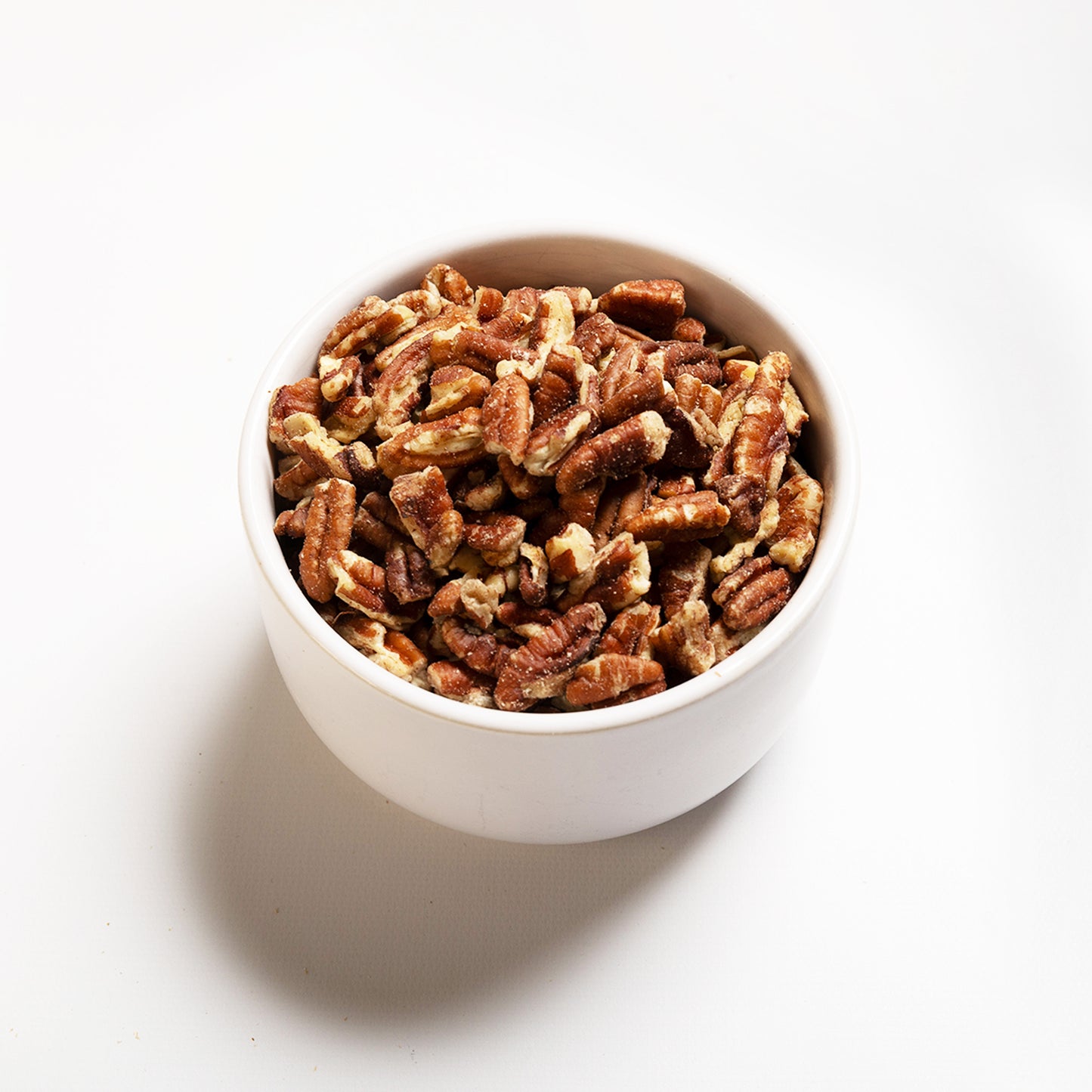 A bowl filled with chopped pecans, view is at an angle 