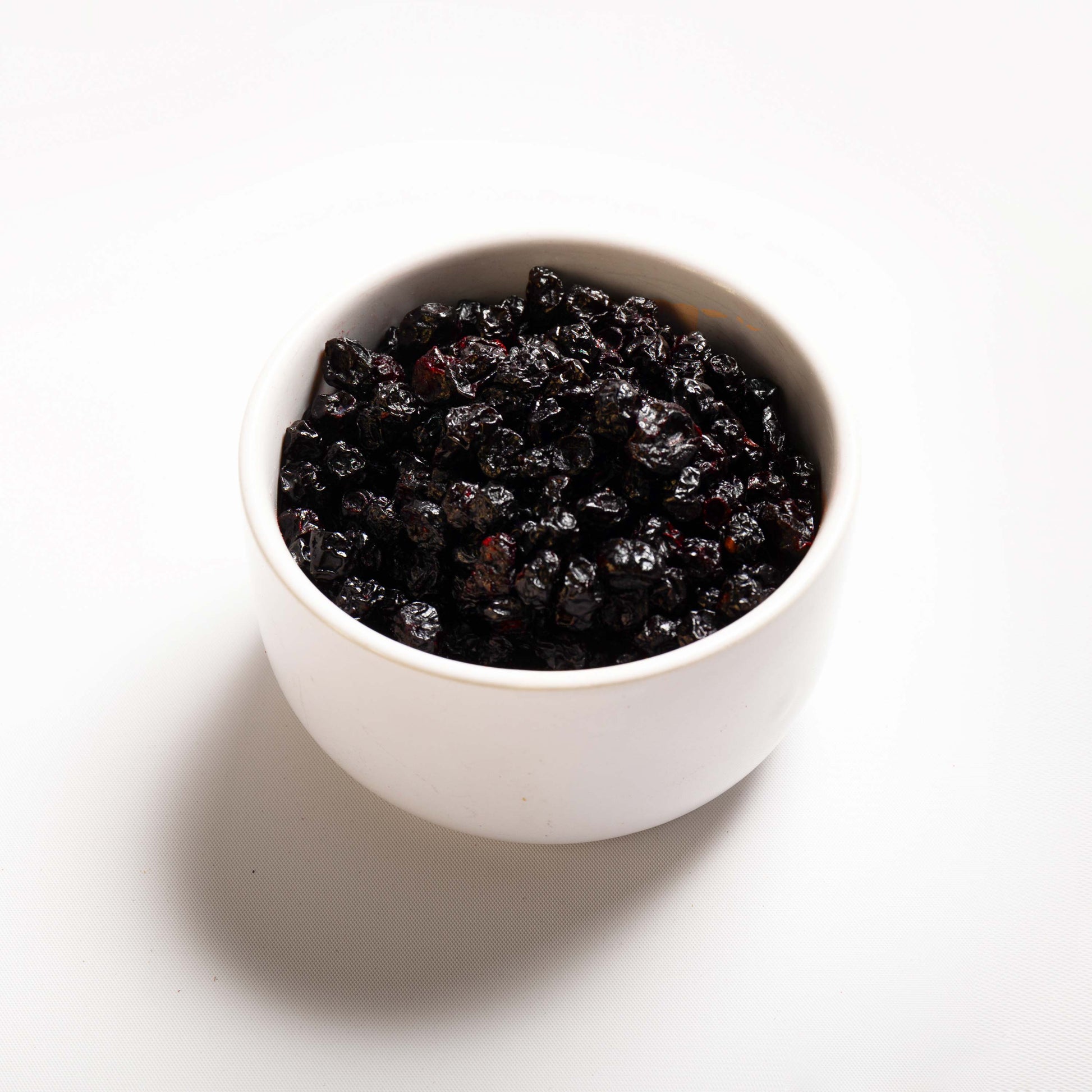 A white bowl filled with Dried Cultivated Blueberries from RHBULK 
