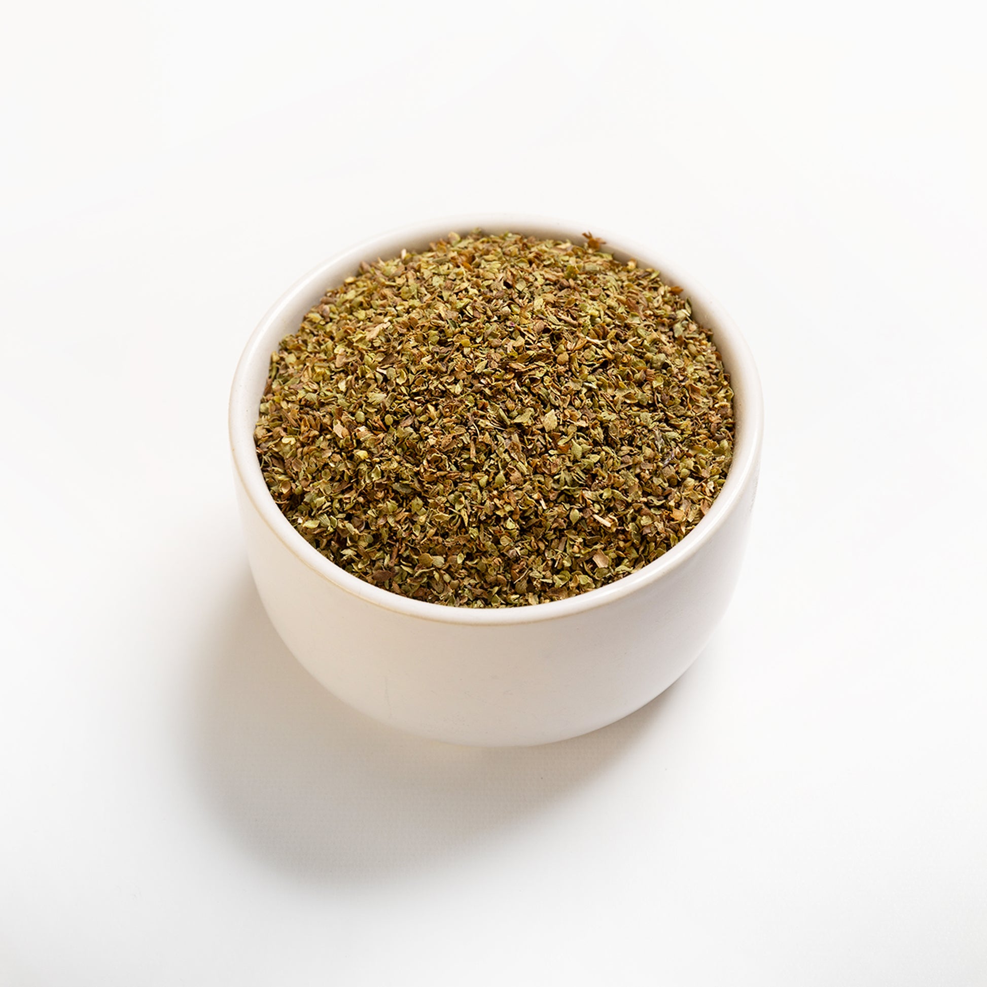 A bowl filled with dried oregano leaves.