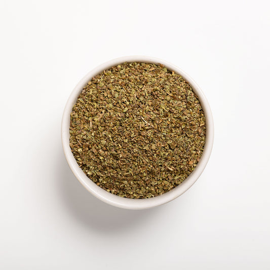 A bowl filled with dried oregano leaves on a white background.