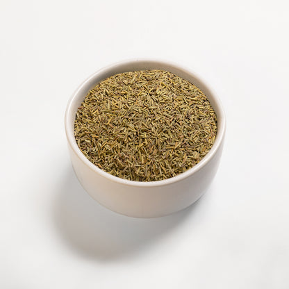 A bowl filled with dried rosemary leaves on a white background.