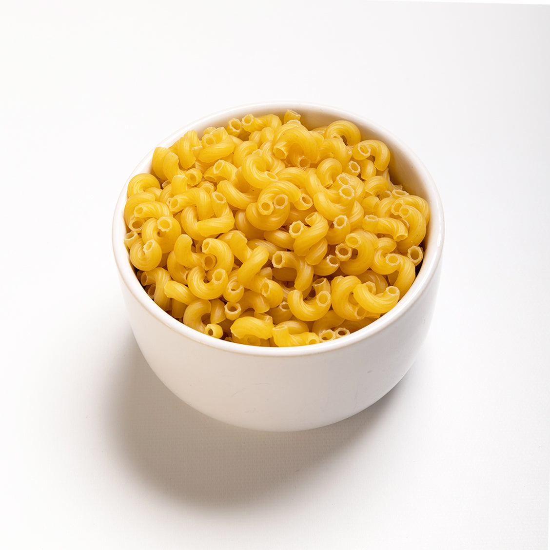 A bowl of dry elbow macaroni pasta made from Durum and semolina wheats