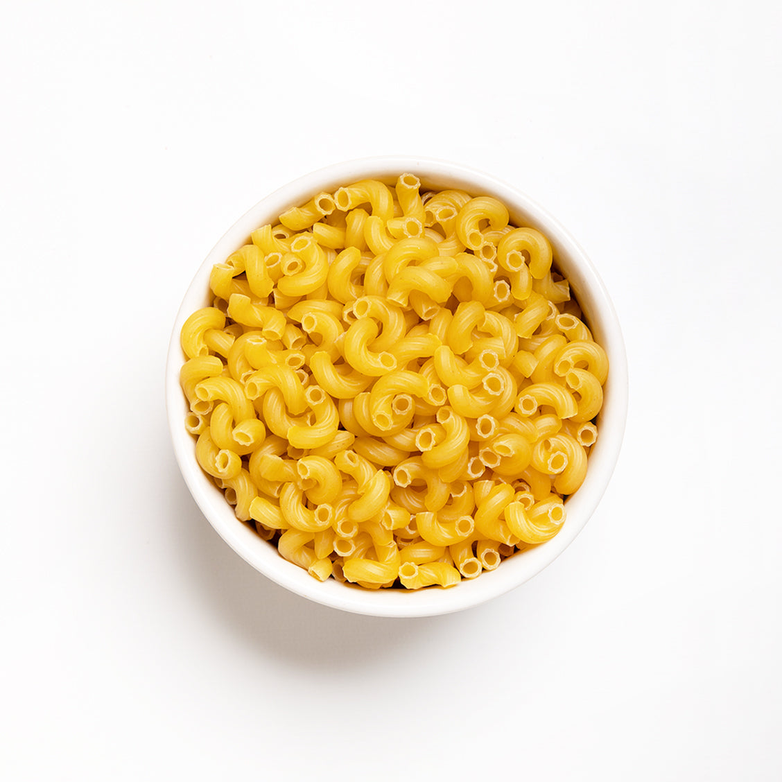 A bowl of dry elbow macaroni pasta.