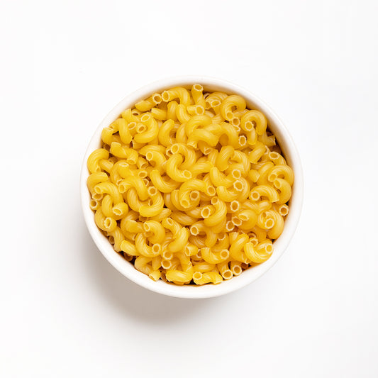 A bowl of dry elbow macaroni pasta.