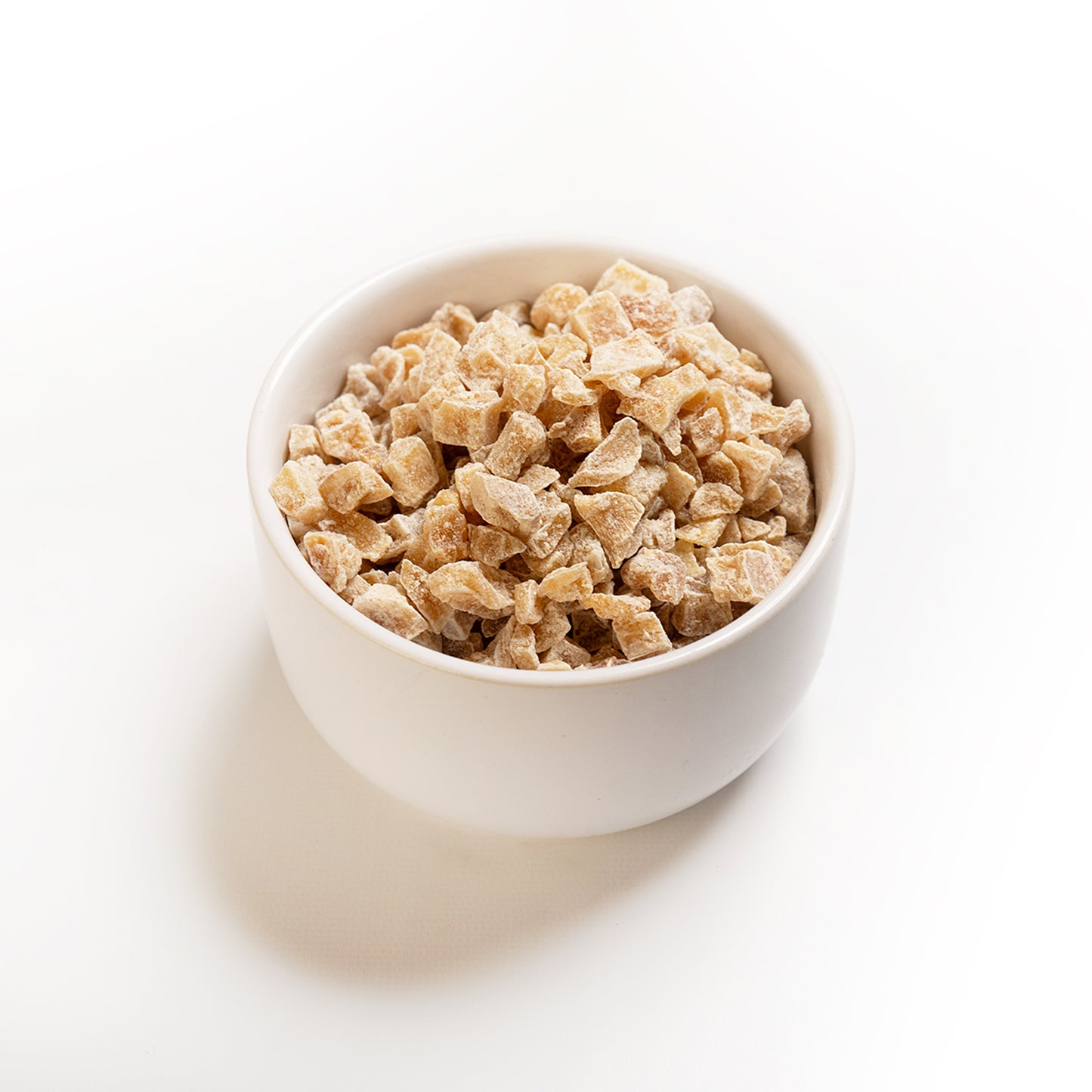 A bowl of RHBULK crystallized ginger pieces on a white background.