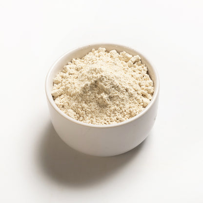 A bowl filled with sorghum flour on a white background.