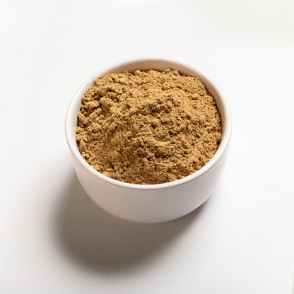A bowl of ground ginger on a white background.