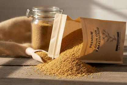 Open brown paper bag of premium ground golden flaxseed with a jar and scoop in the background on a wooden surface.