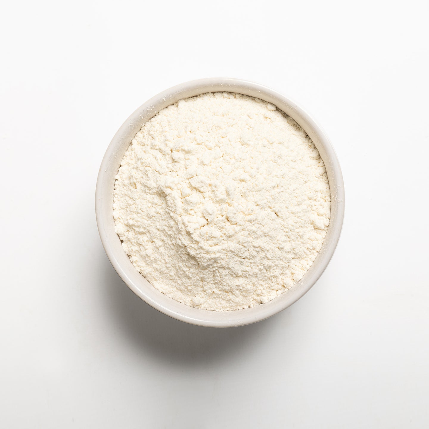 White bowl filled with High Gluten bread flour on a white background