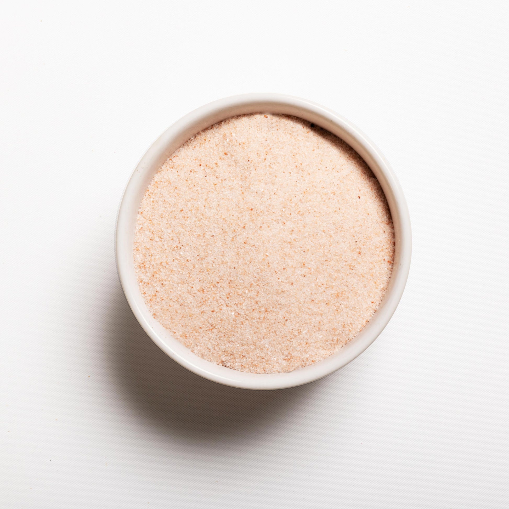 A white bowl filled with Himalayan Pink Salt (finely ground) 