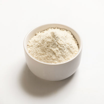A bowl of long grain brown rice flour on a white background.