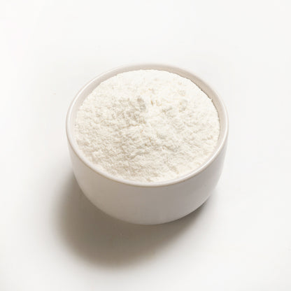 A bowl of long grain white rice flour on a white background.