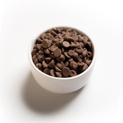 A side view of a bowl of milk chocolate chips 