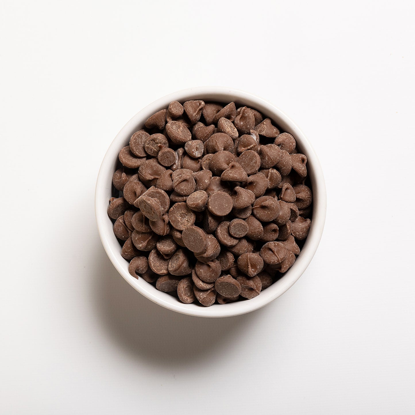 White bowl filled with milk chocolate chips 