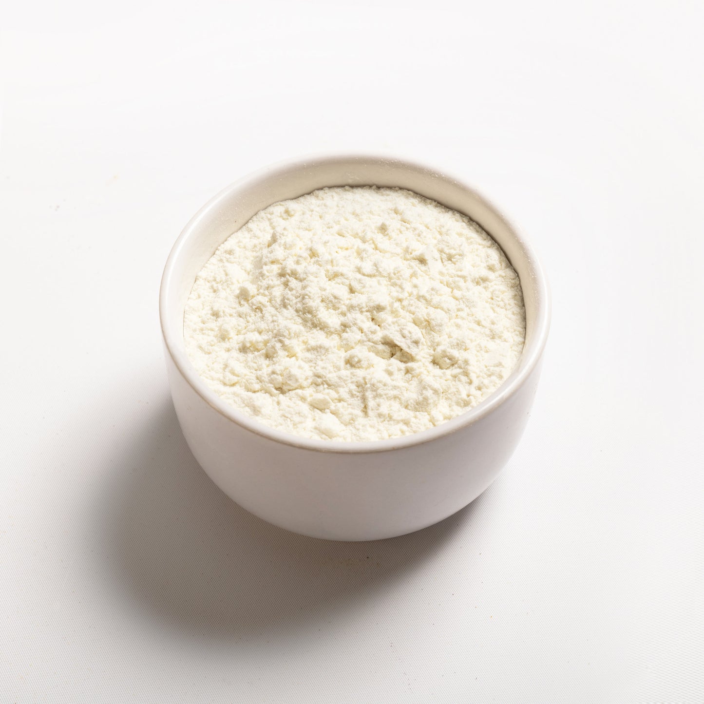 A white bowl filled with Milk Protein Concentrate powder