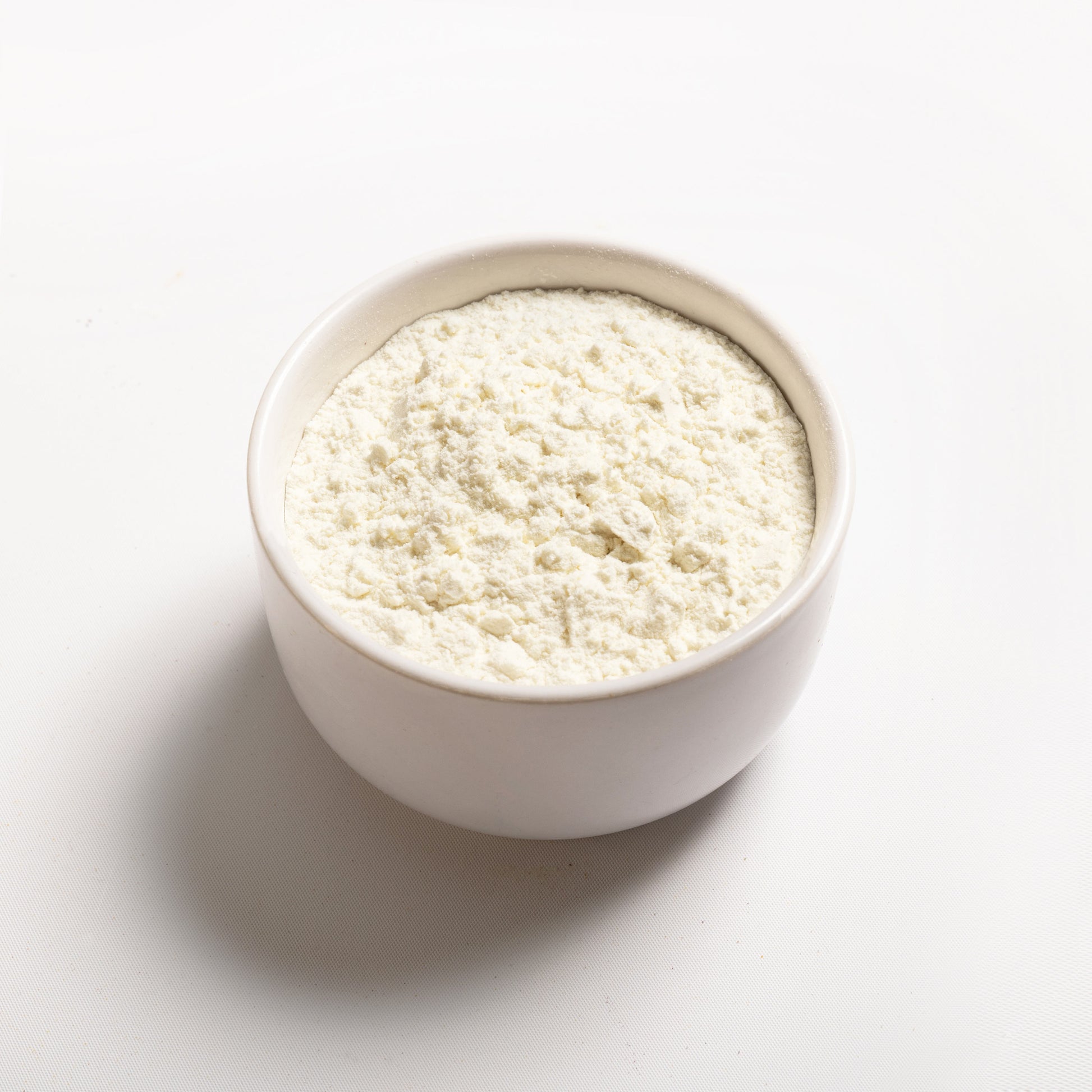 A white bowl filled with Milk Protein Concentrate powder