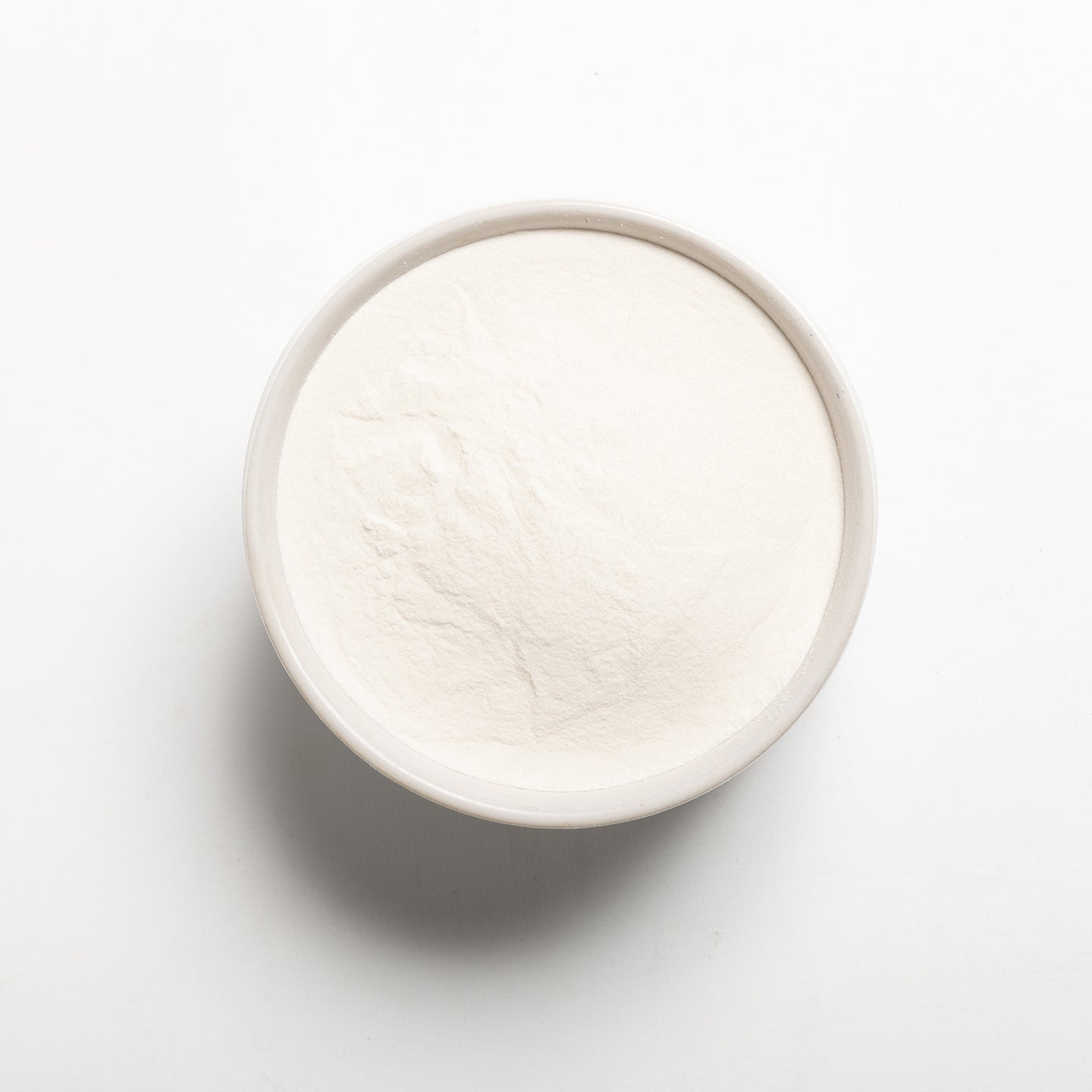 A bowl filled with modified tapioca starch on a light gray background