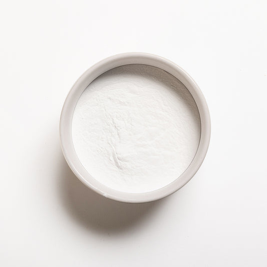 A container filled with white powdery substance on a white background, representing Monocalcium Phosphate Anhydrous (V90)