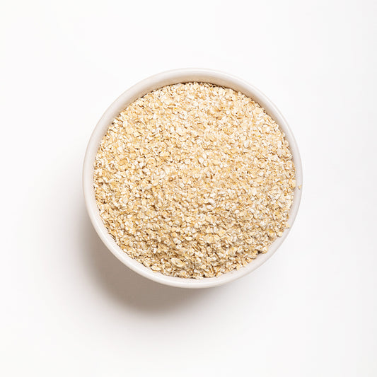A bowl full of quick cooking steel cut oats (Oat Bran) on a white background.