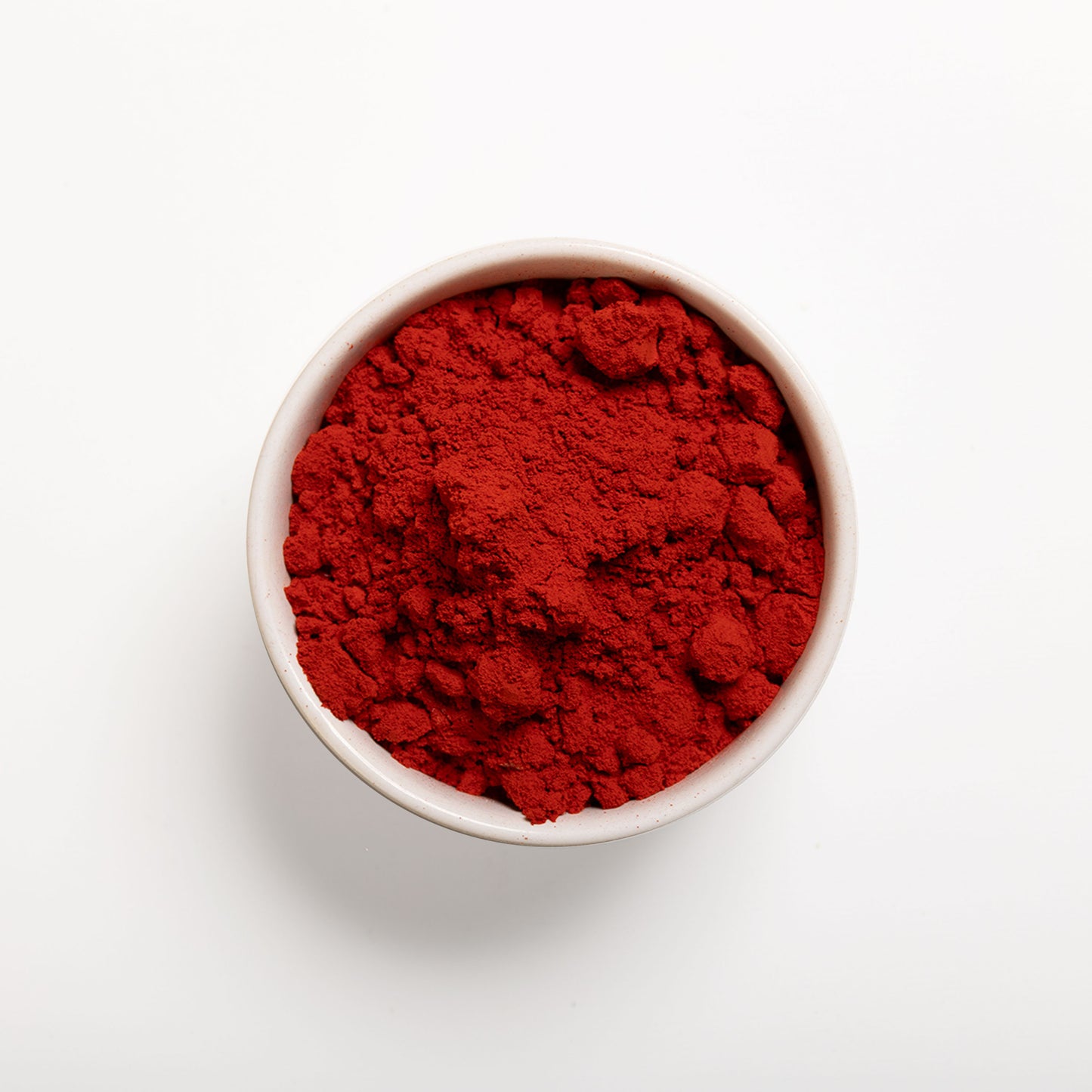 a bowl filled with RHBULK Orange Vegetable Powder on a white background 