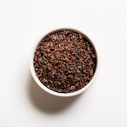 White bowl filled with organic cacao nibs 