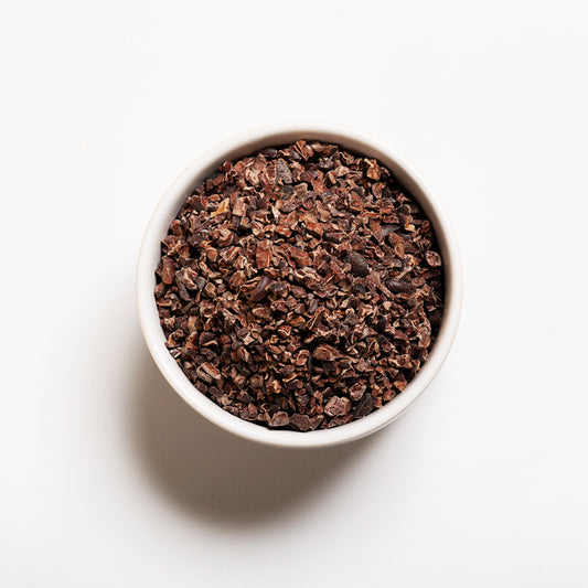 White bowl filled with organic cacao nibs 