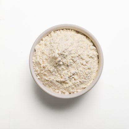 A bowl filled with Organic Bread Flour on a white background