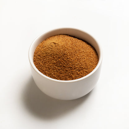 A bowl filled with organic coconut sugar on a white background.