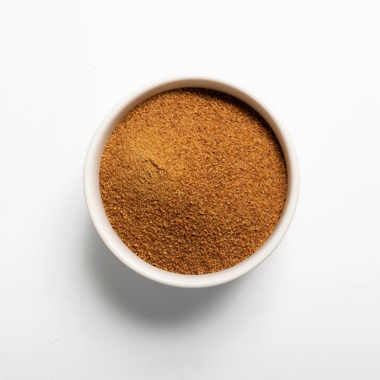 A bowl filled with Organic Coconut Sugar on a white background
