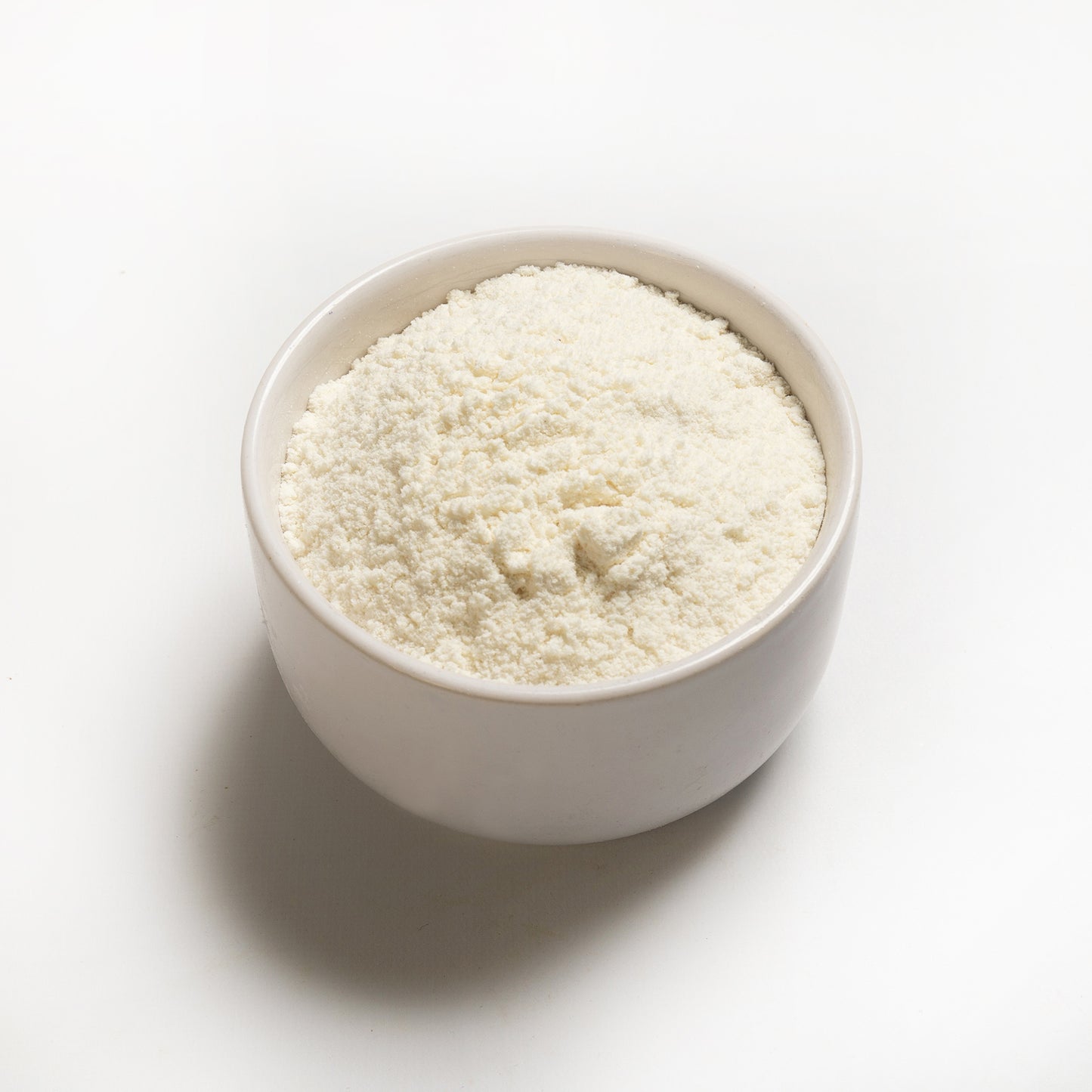 A bowl of organic coconut flour on a white background.