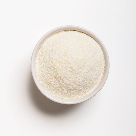 A bowl of Polar White Cornmeal on a white background, showing the fine texture of the cornmeal.