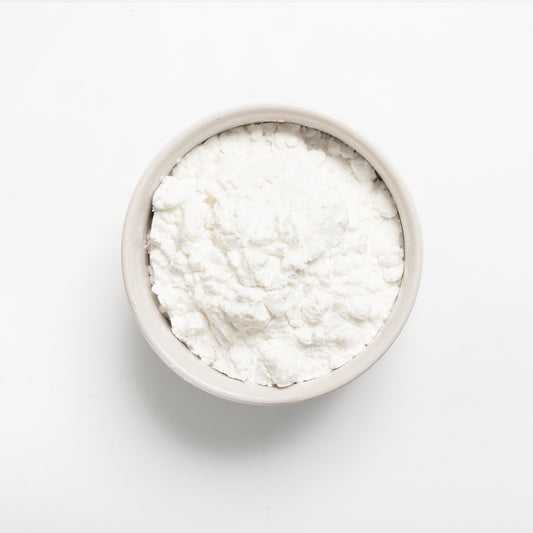 A bowl of white potato starch on a white background.
