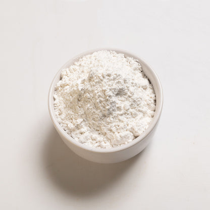 A bowl filled with powdered sugar on a white background.
