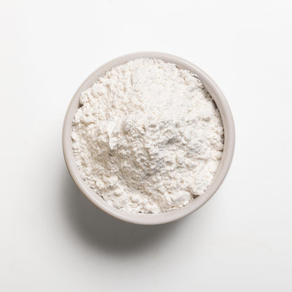 A bowl filled with powdered sugar on a white background.