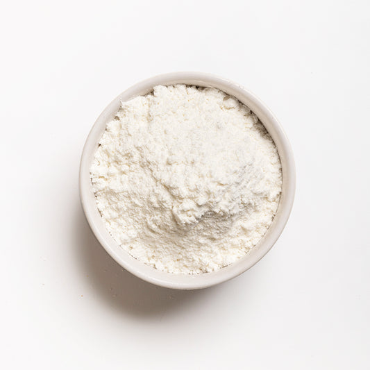 A bowl of snow white corn flour, finely ground, presented on a white background.