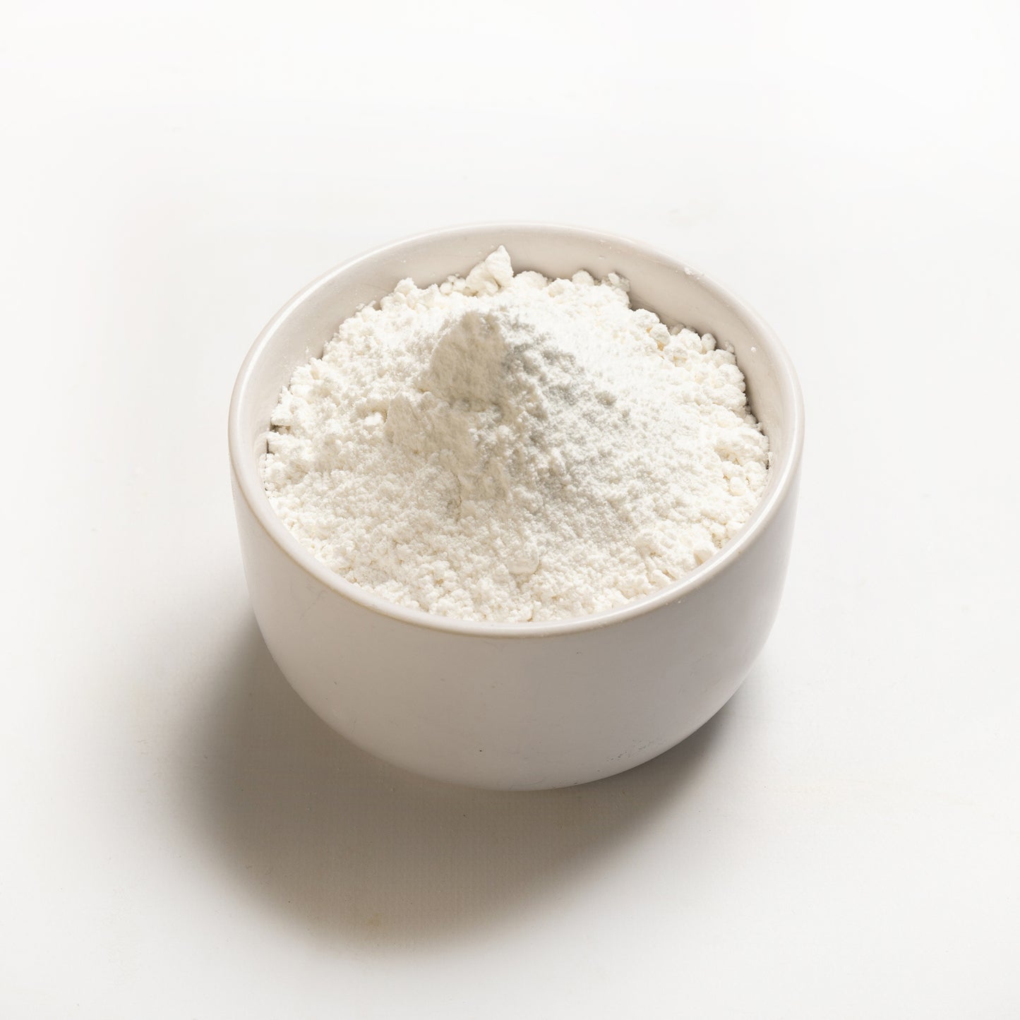 A bowl of white sweet rice flour on a white background.