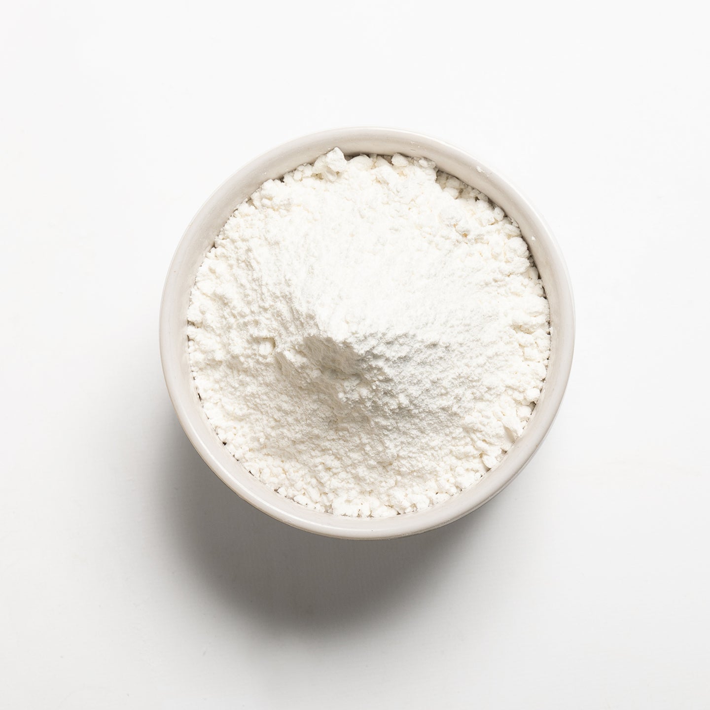 A bowl of white sweet rice flour on a white background.