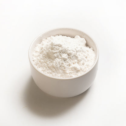 A bowl filled with white tapioca starch on a white background.