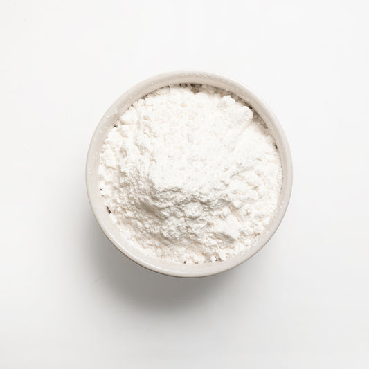 A bowl filled with white tapioca starch on a white background.