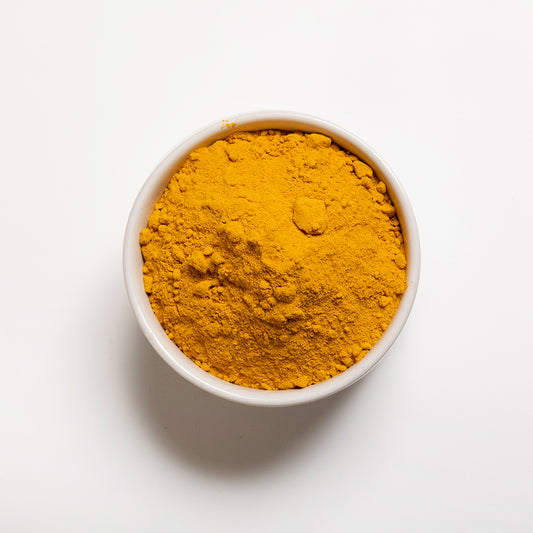 Turmeric powder in a white bowl from a top view 