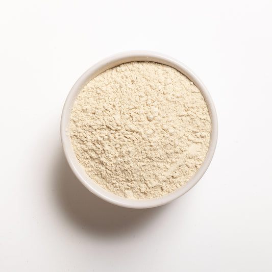 A bowl of unflavored wheat protein isolate powder on a white background.