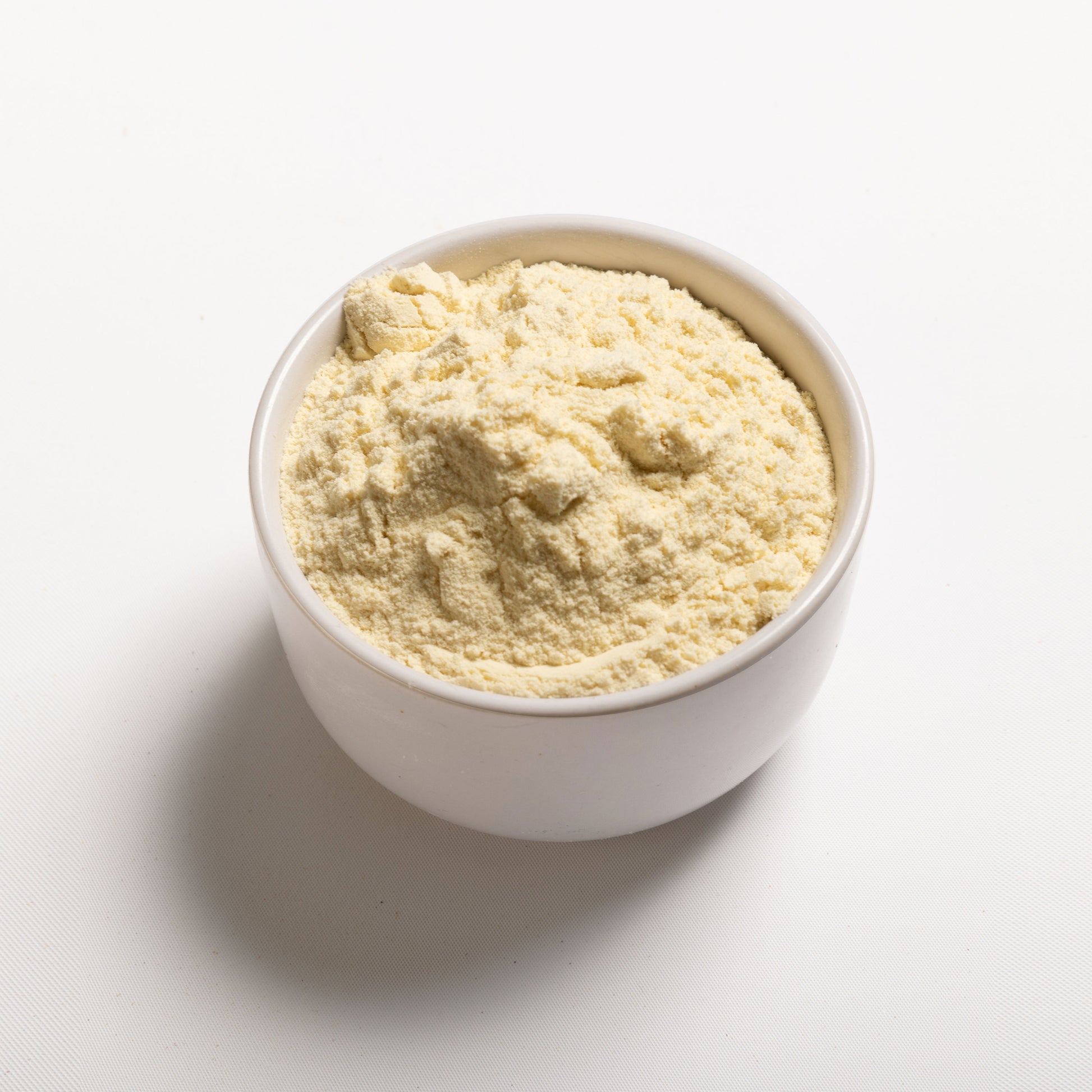 A white bowl filled with whey protein concentrate powder 