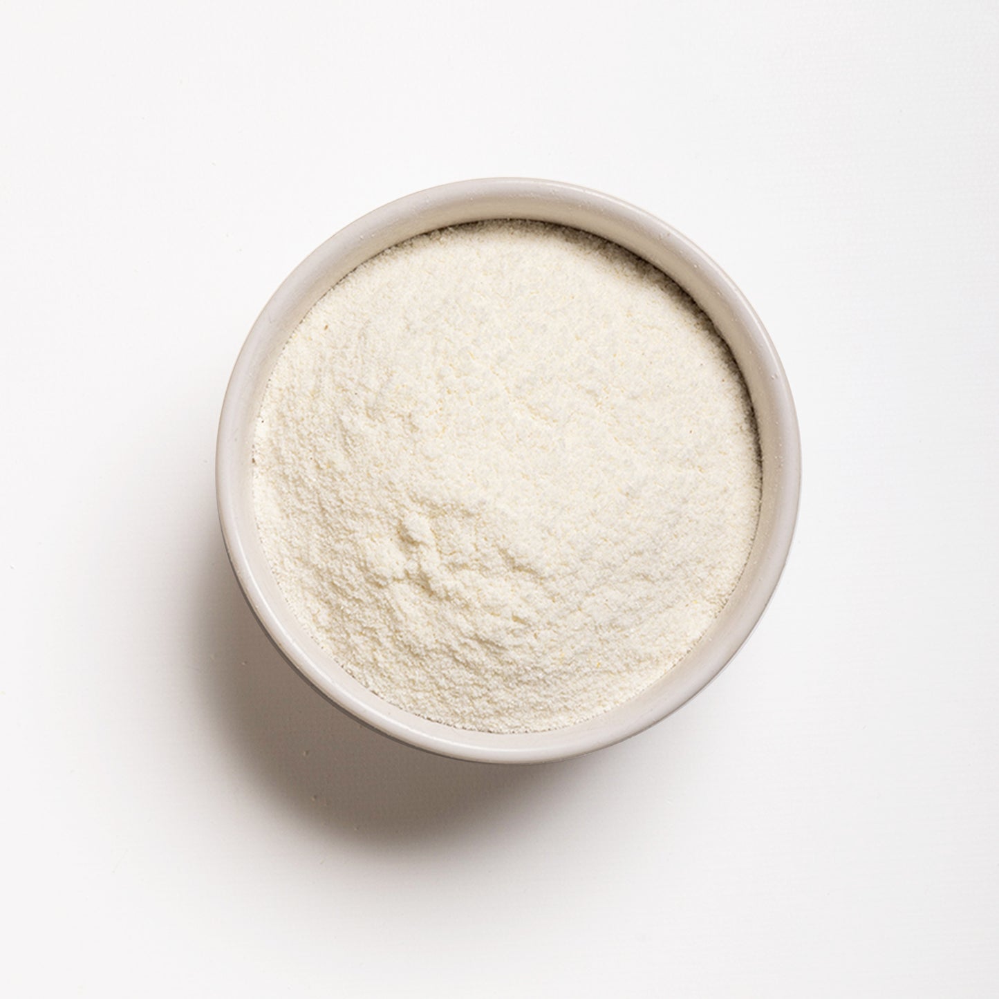 A bowl filled with white arepa flour, which is finely milled cornmeal.