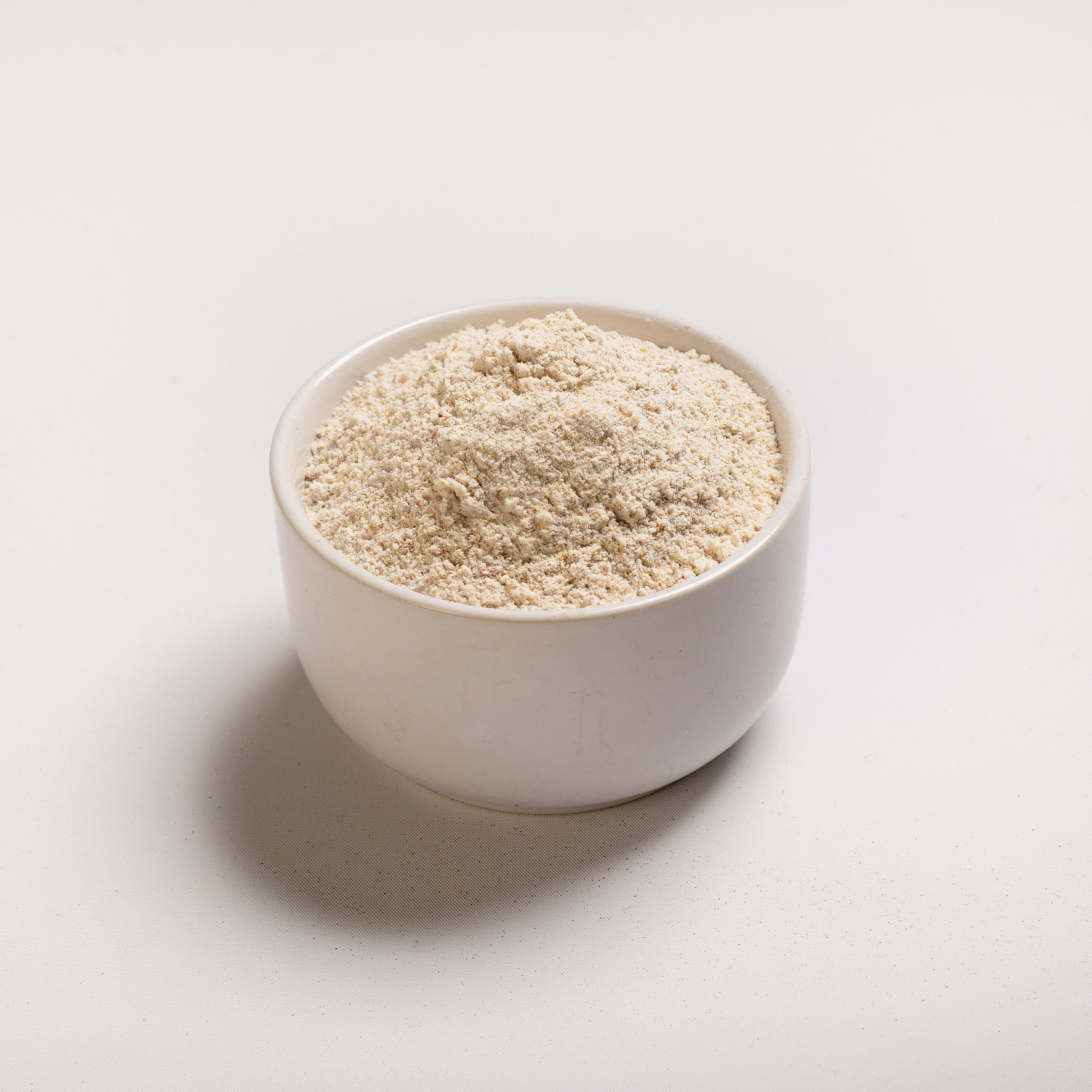 An angle photo of white whole wheat flour on a white background