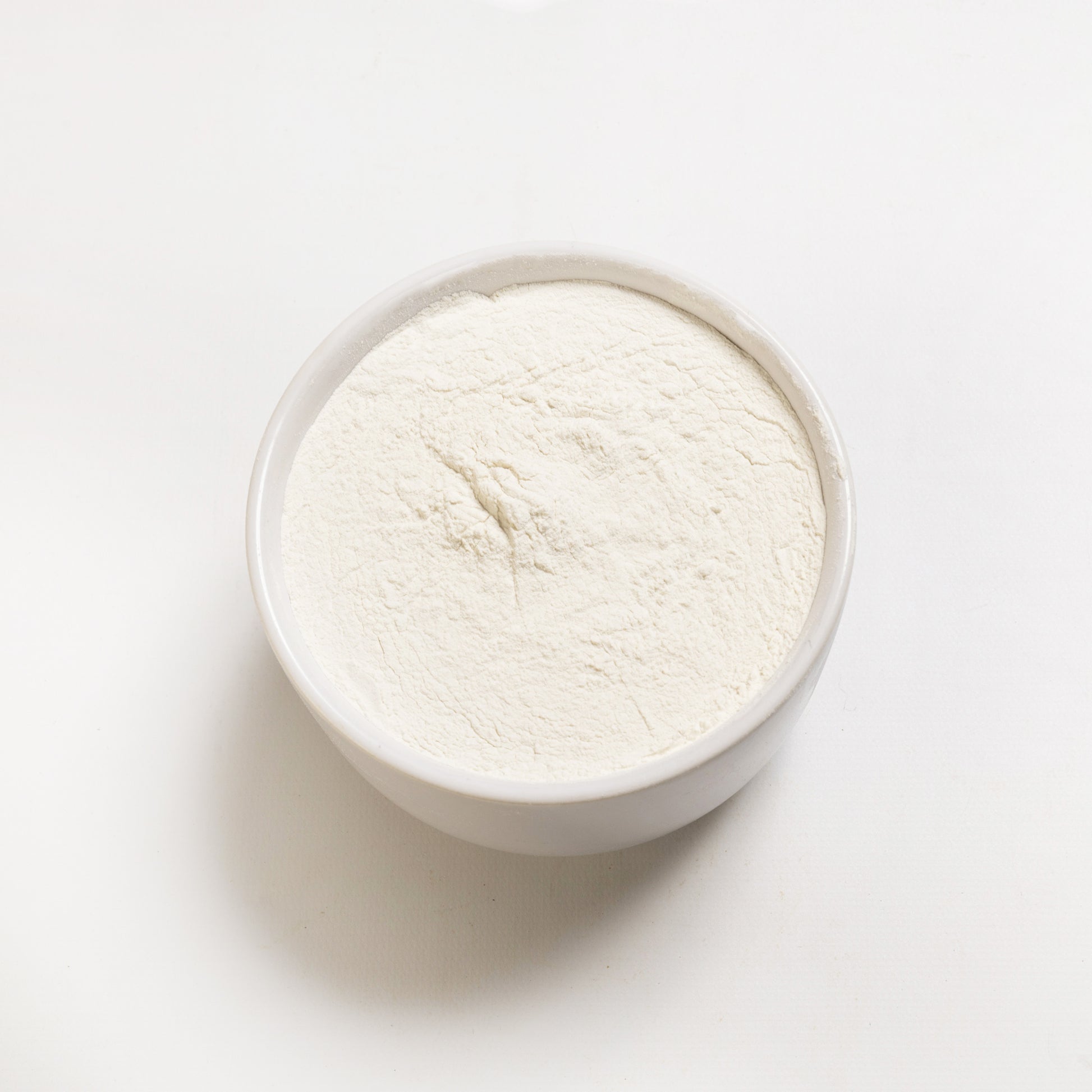 An open container filled with white xanthan gum powder (200 mesh) 