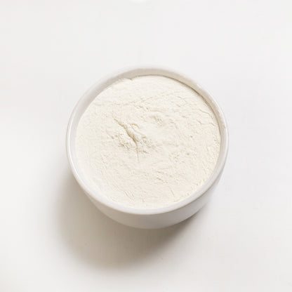 An open container filled with white xanthan gum powder (200 mesh) 