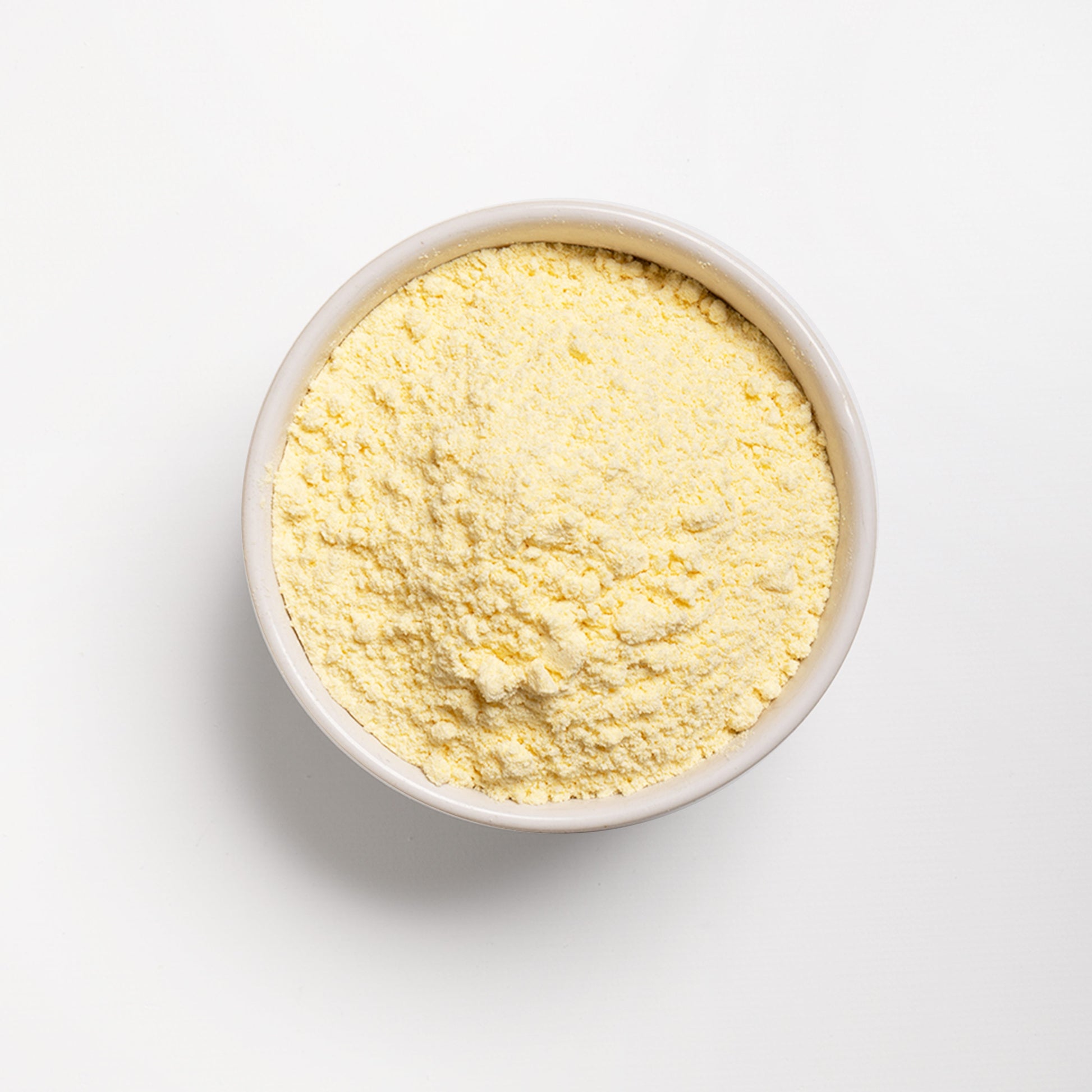 A bowl of yellow corn flour on a white background.